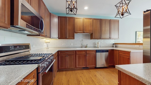 301 W Eagle Ct, Waukegan, IL 60087 - kitchen featuring appliances with stainless steel finishes, light countertops, brown cabinetry, and recessed lighting
