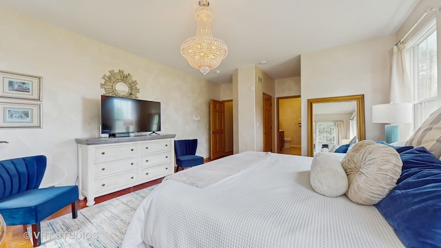 301 W Eagle Ct, Waukegan, IL 60087 - bedroom with multiple windows, a chandelier, wood finished floors, and ensuite bath