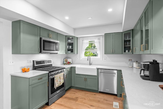 2945 Worcester Ln, Aurora, IL 60504 - kitchen with green cabinets, appliances with stainless steel finishes, glass insert cabinets, light wood-style floors, and recessed lighting