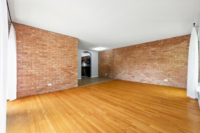 9516 S Kildare Ave Unit 3S, Oak Lawn, IL 60453 - unfurnished living room with brick wall, wood finished floors, and arched walkways