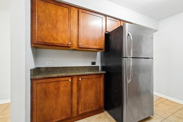 9516 S Kildare Ave Unit 3S, Oak Lawn, IL 60453 - kitchen featuring freestanding refrigerator, light tile patterned flooring, brown cabinets, and dark stone countertops