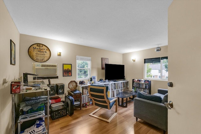 611 W White St, Champaign, IL 61820 - living area featuring healthy amount of natural light, wood finished floors, and a wall mounted air conditioner