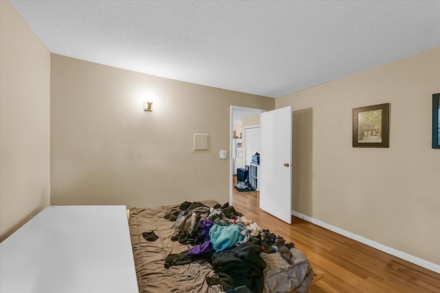 611 W White St, Champaign, IL 61820 - unfurnished bedroom featuring light wood-style floors and a textured ceiling