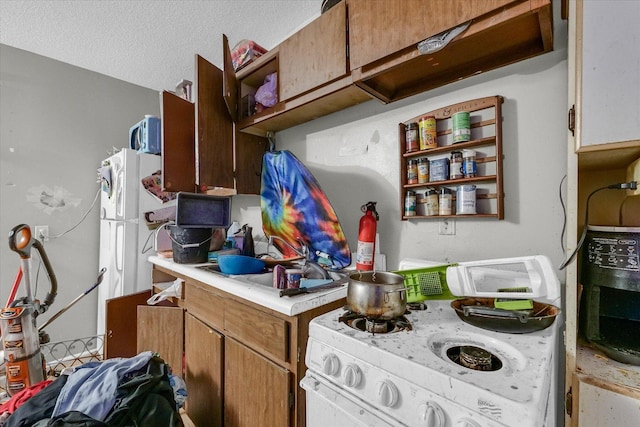 611 W White St, Champaign, IL 61820 - kitchen featuring range, light countertops, open shelves, and a textured ceiling