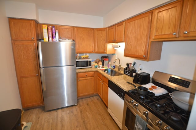 1455 N Winslowe Dr Unit 302, Palatine, IL 60074 - kitchen featuring appliances with stainless steel finishes, light wood-type flooring, and brown cabinetry