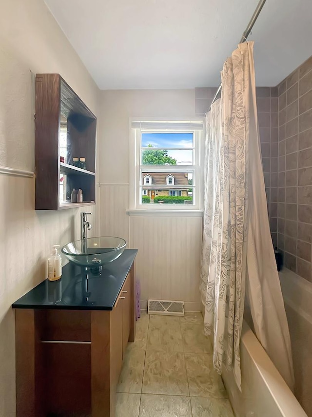 1639 S Highland Ave, Freeport, IL 61032 - bathroom featuring vanity, shower / tub combo, and a wainscoted wall