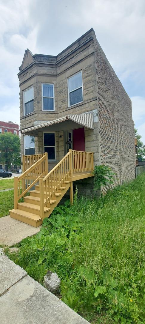1556 S Spaulding Ave, Chicago, IL 60623 - view of front of house with stone siding, a porch, and stairway