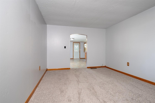 112 NW Adams St N, Hopedale, IL 61747 - unfurnished room featuring arched walkways, carpet floors, and a textured ceiling