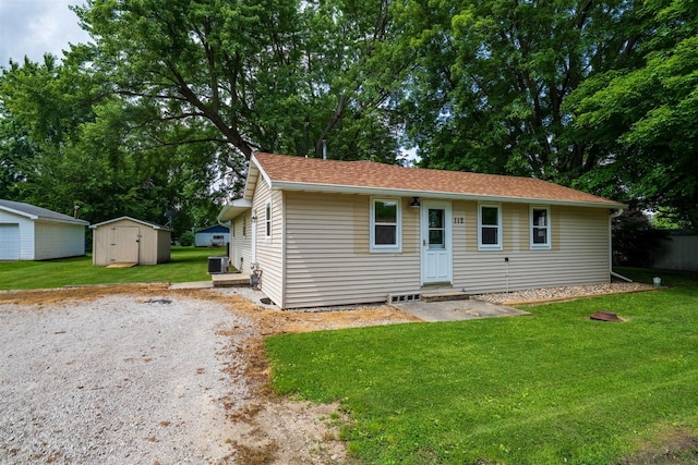 112 NW Adams St N, Hopedale, IL 61747 - view of front of property with entry steps, a front lawn, a storage unit, and roof with shingles