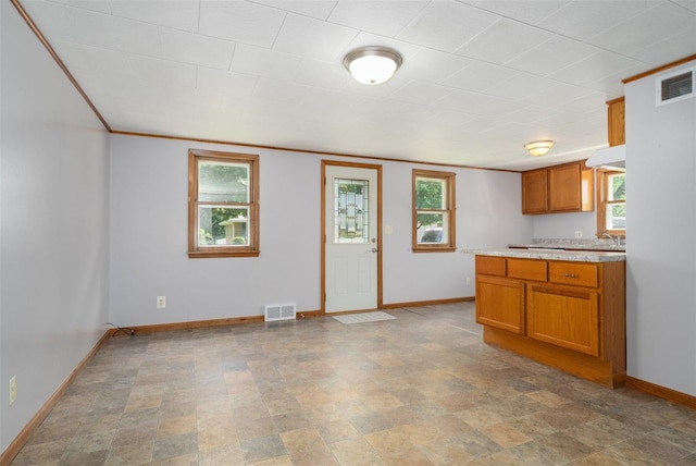 112 NW Adams St N, Hopedale, IL 61747 - kitchen with brown cabinetry, crown molding, and stone finish flooring