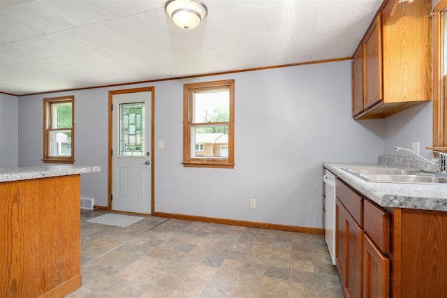 112 NW Adams St N, Hopedale, IL 61747 - kitchen with brown cabinets, light countertops, crown molding, white dishwasher, and stone finish flooring