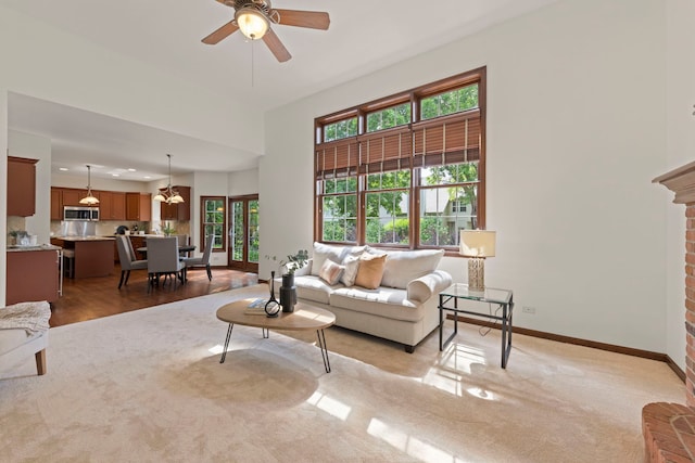 609 Spruce Ct, Oswego, IL 60543 - living area featuring healthy amount of natural light, a chandelier, ceiling fan, and light colored carpet