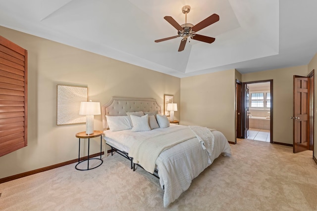 609 Spruce Ct, Oswego, IL 60543 - bedroom featuring a tray ceiling, light colored carpet, ensuite bathroom, and ceiling fan