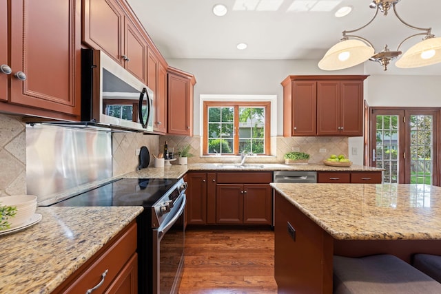 609 Spruce Ct, Oswego, IL 60543 - kitchen featuring appliances with stainless steel finishes, recessed lighting, dark wood-style flooring, light stone countertops, and backsplash
