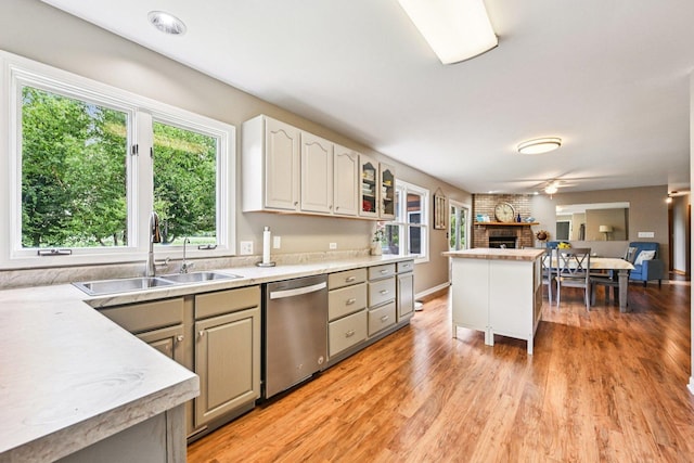 6180 Elm St, Union, IL 60180 - kitchen with dishwasher, open floor plan, a brick fireplace, light countertops, and light wood-style floors