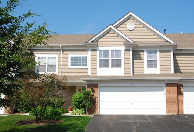 341 S Lancelot Ln, Palatine, IL 60074 - view of property featuring brick siding, driveway, a shingled roof, and an attached garage