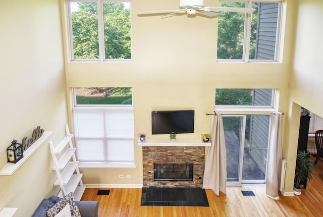 341 S Lancelot Ln, Palatine, IL 60074 - living area with wood finished floors, a towering ceiling, a stone fireplace, a ceiling fan, and plenty of natural light