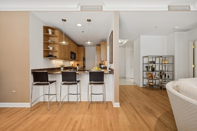 415 E N Water St Unit 806, Chicago, IL 60611 - kitchen featuring open shelves, black microwave, brown cabinets, light wood-type flooring, and a peninsula