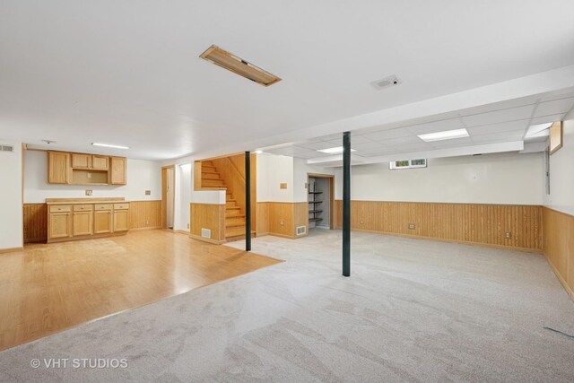 238 Weaver Dr, Cary, IL 60013 - basement featuring stairway, wood walls, light colored carpet, a wainscoted wall, and light wood-type flooring