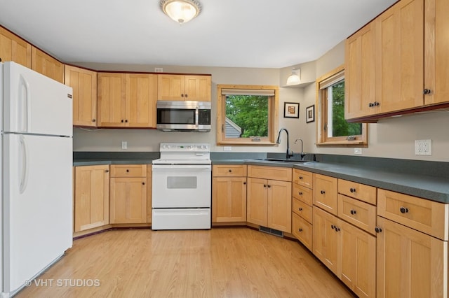 238 Weaver Dr, Cary, IL 60013 - kitchen with white appliances, light brown cabinetry, dark countertops, and light wood-style flooring