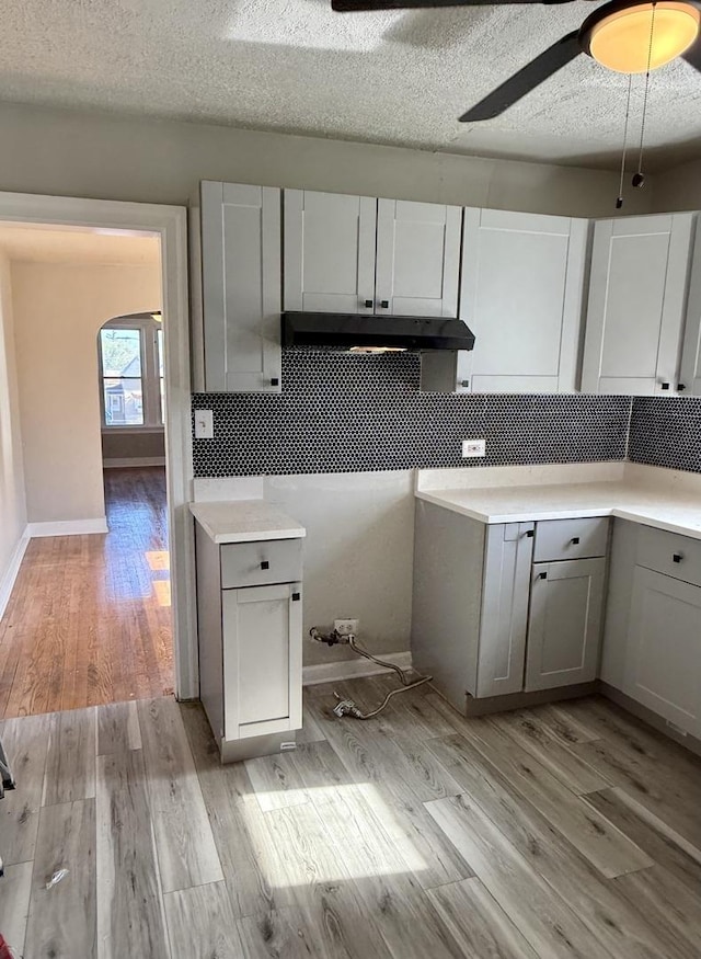 1827 170th St, Hazel Crest, IL 60429 - kitchen with gray cabinetry, under cabinet range hood, light wood finished floors, arched walkways, and light countertops