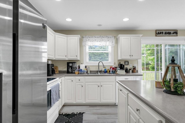 1707 Lydia Ct, Urbana, IL 61802 - kitchen with freestanding refrigerator, white electric range oven, healthy amount of natural light, light wood-style flooring, and recessed lighting
