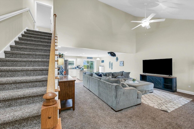 1707 Lydia Ct, Urbana, IL 61802 - living area with light colored carpet, stairs, a ceiling fan, and high vaulted ceiling
