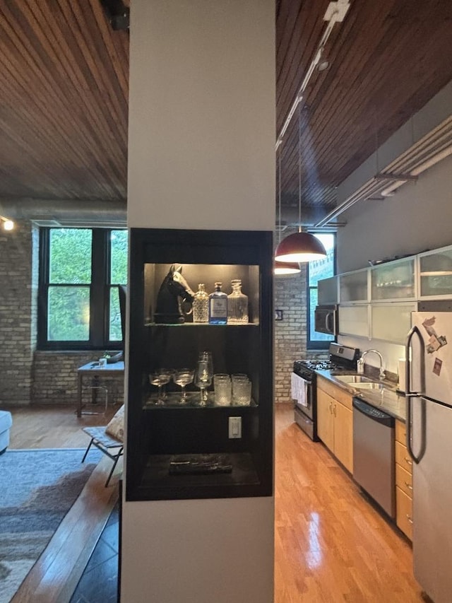 2510 N Wayne Ave Unit 203, Chicago, IL 60614 - kitchen featuring appliances with stainless steel finishes, brick wall, rail lighting, wooden ceiling, and light wood-style flooring