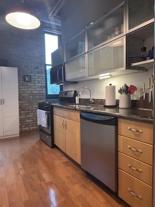 2510 N Wayne Ave Unit 203, Chicago, IL 60614 - kitchen featuring dishwasher, gas range, wood finished floors, brick wall, and open shelves