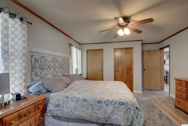 701 Dudley St, Liberty, IL 62347 - bedroom with light wood-type flooring, ornamental molding, multiple closets, a ceiling fan, and a textured ceiling