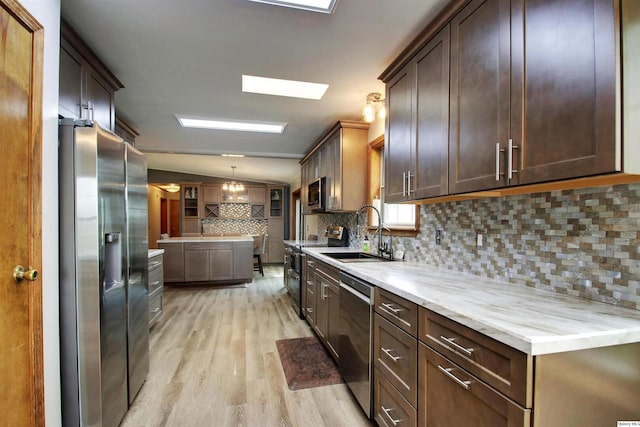 701 Dudley St, Liberty, IL 62347 - kitchen with stainless steel appliances, light wood-type flooring, tasteful backsplash, dark brown cabinetry, and hanging light fixtures