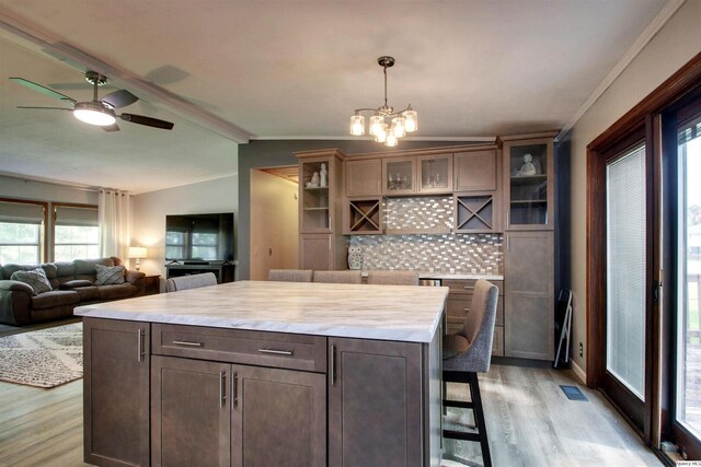 701 Dudley St, Liberty, IL 62347 - kitchen with light wood finished floors, tasteful backsplash, light countertops, a chandelier, and glass insert cabinets