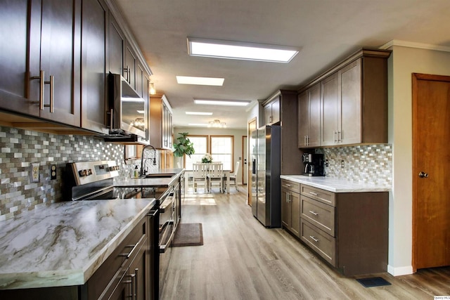 701 Dudley St, Liberty, IL 62347 - kitchen with stainless steel appliances, light wood finished floors, decorative backsplash, and dark brown cabinetry