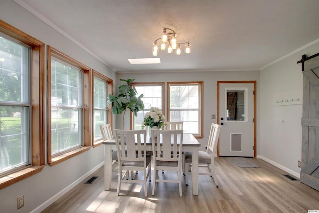 701 Dudley St, Liberty, IL 62347 - dining area featuring a barn door, light wood-type flooring, a chandelier, and ornamental molding