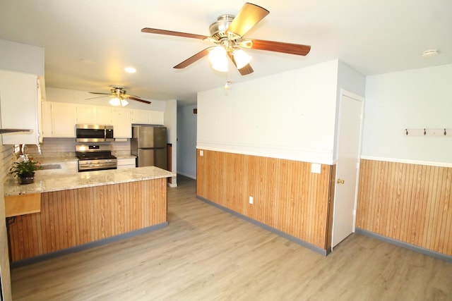9682 Orr Ln, Winnebago, IL 61088 - kitchen featuring appliances with stainless steel finishes, light wood-type flooring, backsplash, a peninsula, and ceiling fan