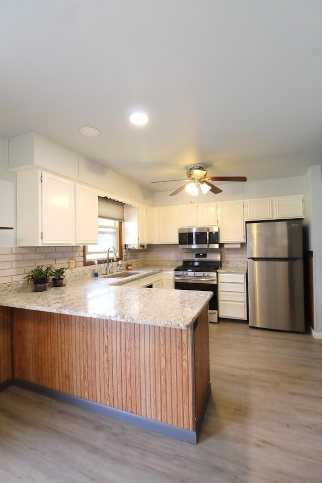 9682 Orr Ln, Winnebago, IL 61088 - kitchen with stainless steel appliances, a peninsula, backsplash, light stone countertops, and recessed lighting