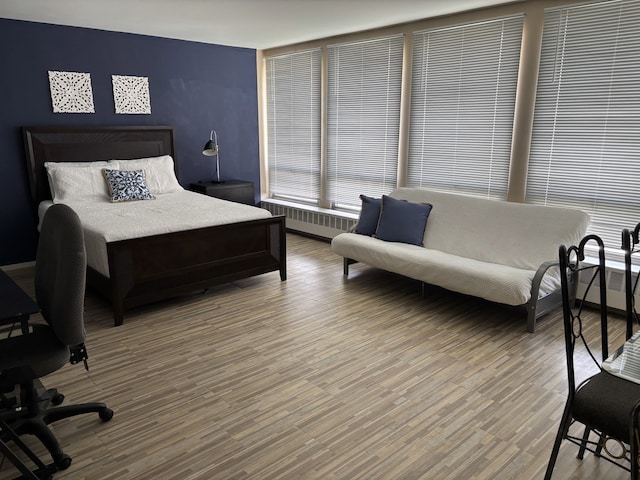 1450 E 55th Pl Unit 927S, Chicago, IL 60615 - bedroom featuring radiator heating unit and wood finished floors