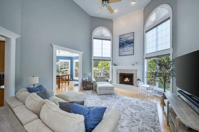 624 Pottawatomie Trl, Batavia, IL 60510 - living area with a high ceiling, a ceiling fan, light wood-style flooring, and a tiled fireplace