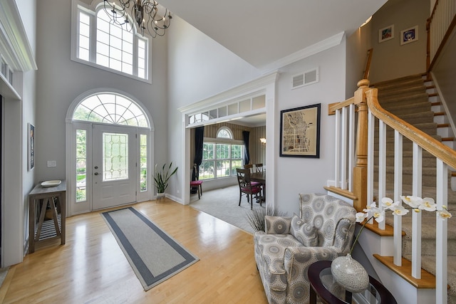 624 Pottawatomie Trl, Batavia, IL 60510 - foyer entrance featuring a towering ceiling, stairs, wood finished floors, a chandelier, and crown molding