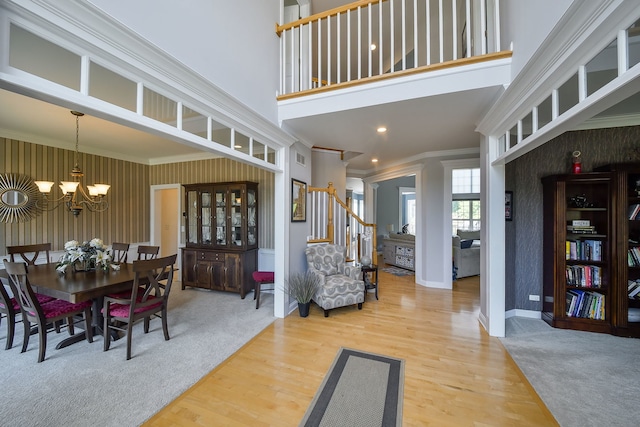 624 Pottawatomie Trl, Batavia, IL 60510 - dining space with wallpapered walls, stairway, a chandelier, ornamental molding, and wood finished floors