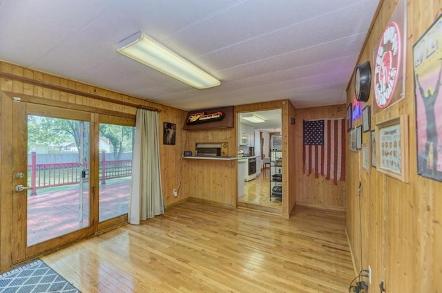 449 W 6th St, Braidwood, IL 60408 - kitchen with wood walls, light wood-style flooring, white stove, and stainless steel microwave