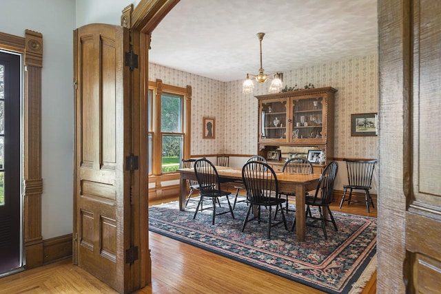 466 Quail Trap Rd, Caledonia, IL 61011 - dining area with wallpapered walls, a chandelier, wainscoting, and light wood finished floors