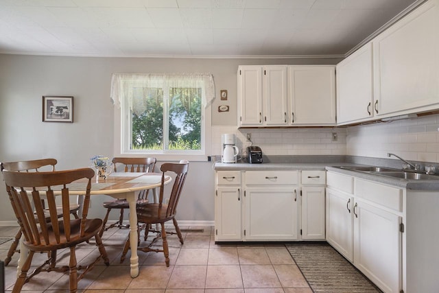 466 Quail Trap Rd, Caledonia, IL 61011 - kitchen featuring decorative backsplash, white cabinetry, light tile patterned floors, and crown molding