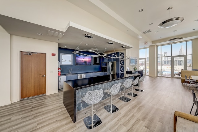 1841 S Calumet Ave Unit 1302, Chicago, IL 60616 - kitchen with appliances with stainless steel finishes, light wood-type flooring, a kitchen breakfast bar, dark countertops, and a center island