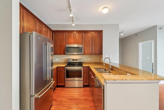 1841 S Calumet Ave Unit 1302, Chicago, IL 60616 - kitchen with stainless steel appliances, a peninsula, light wood-style floors, light stone countertops, and tasteful backsplash