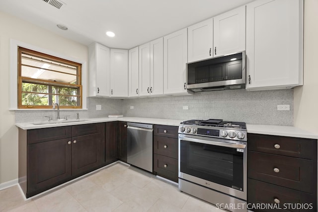 140 W Adams St, Villa Park, IL 60181 - kitchen with appliances with stainless steel finishes, white cabinetry, light countertops, and dark brown cabinets