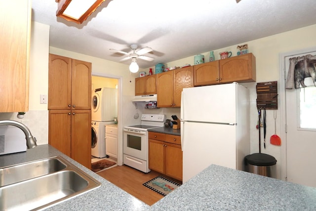 403 10th St, Mazon, IL 60444 - kitchen featuring white appliances, under cabinet range hood, estacked washer and dryer, light wood-style flooring, and ceiling fan