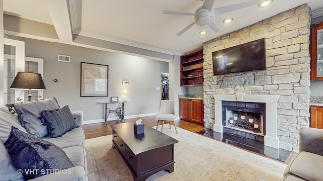 4550 N Malden St Unit 1W, Chicago, IL 60640 - living room featuring a ceiling fan, wood finished floors, built in features, crown molding, and a stone fireplace