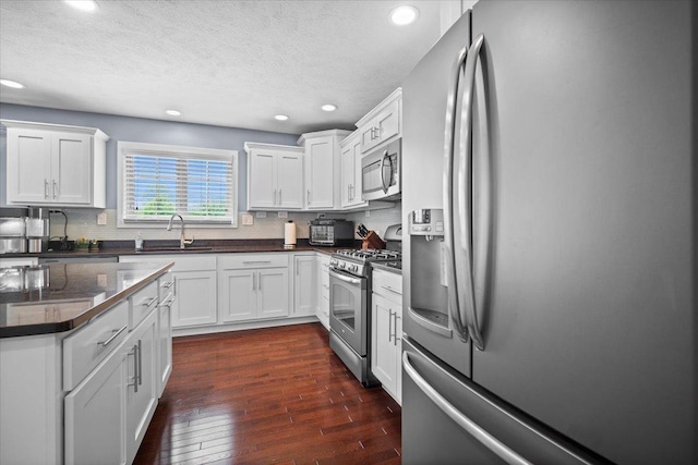 2321 Corrigan Way, Normal, IL 61761 - kitchen featuring appliances with stainless steel finishes, recessed lighting, dark wood-style flooring, tasteful backsplash, and white cabinetry
