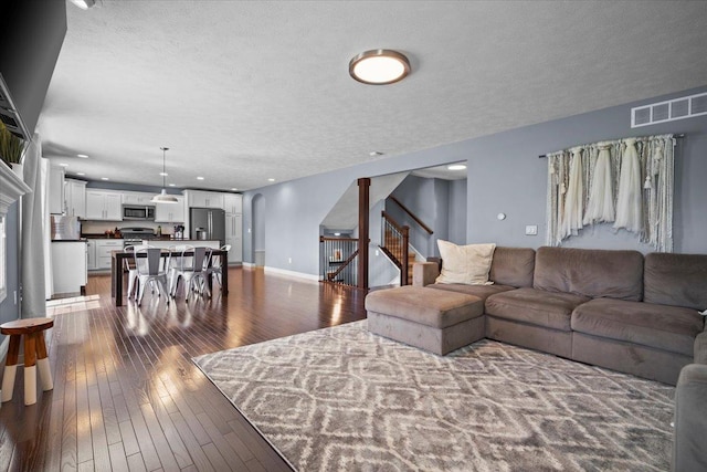 2321 Corrigan Way, Normal, IL 61761 - living room featuring stairs, dark wood finished floors, arched walkways, and a textured ceiling